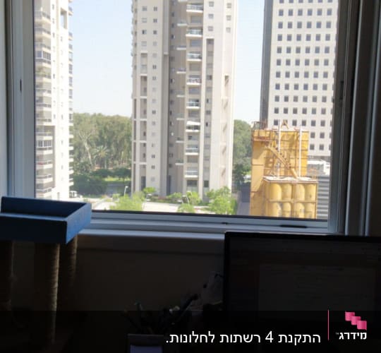 חלון אלומיניום עם נוף של בניינים גבוהים